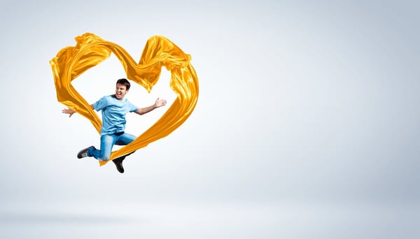 Young man dancing with yellow fabric over white background
